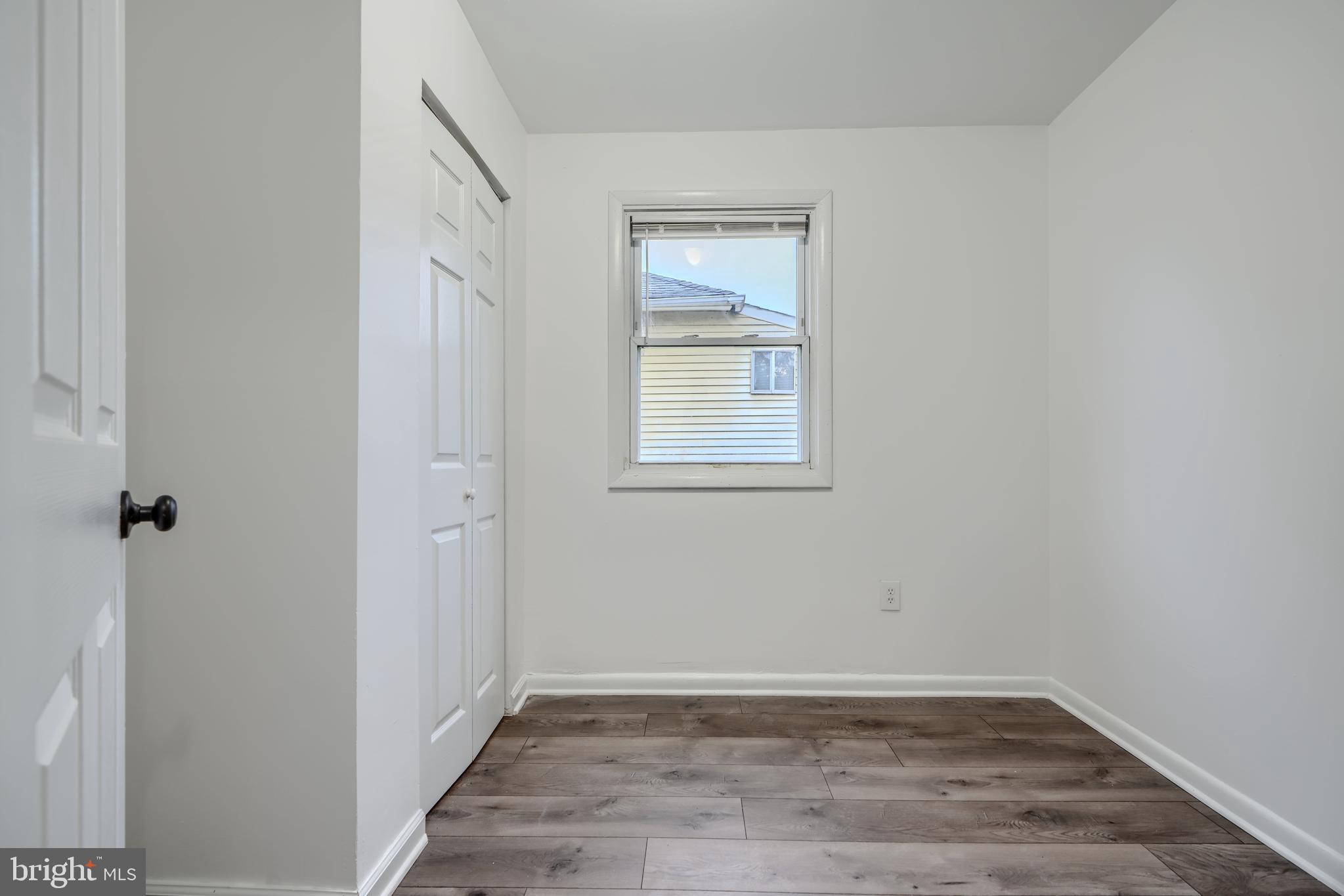 227 Elizabeth Avenue Baltimore, MD 21225 - Photo 17 of 31 a view of an empty room with wooden floor and a window