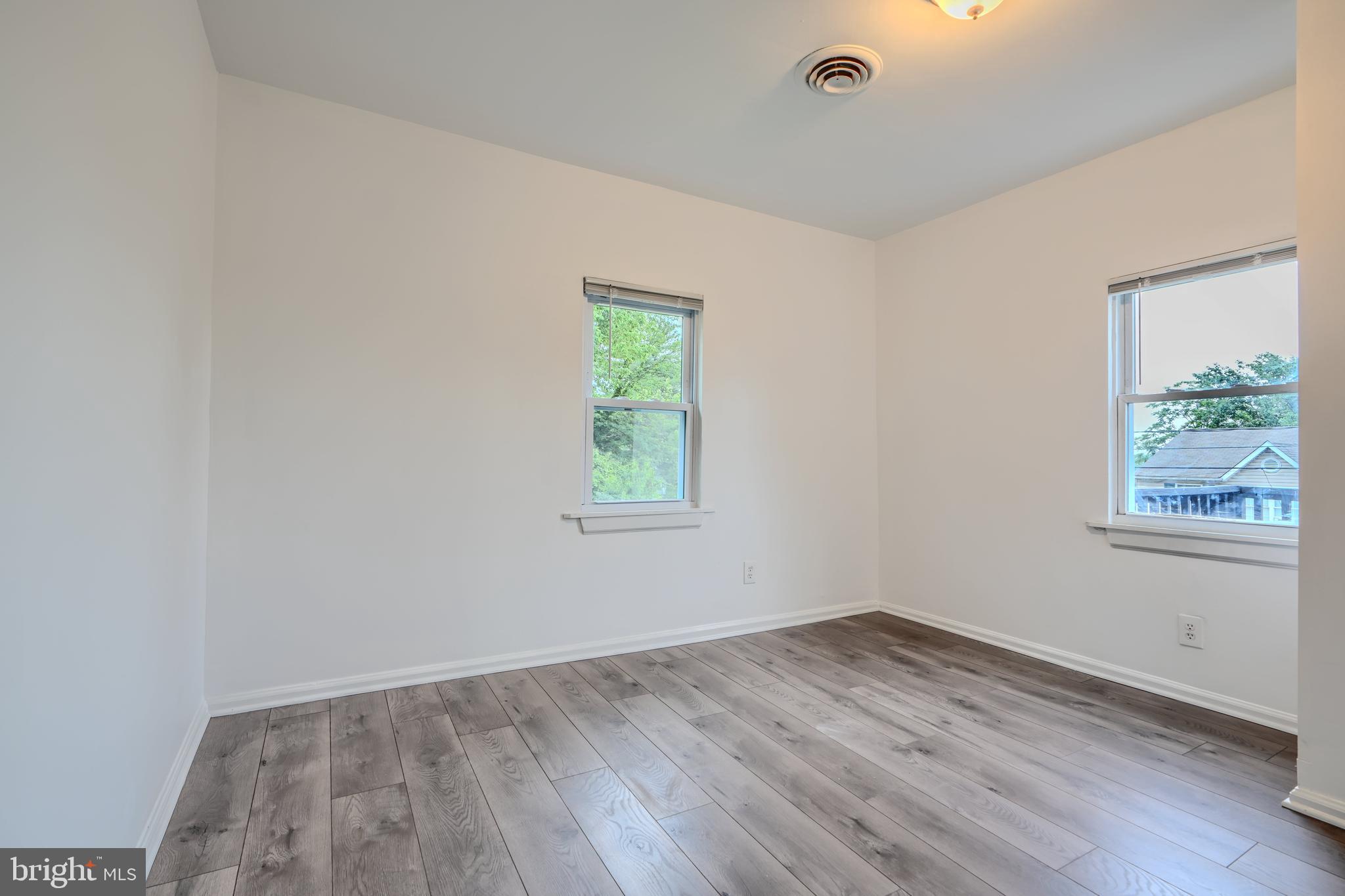 227 Elizabeth Avenue Baltimore, MD 21225 - Photo 20 of 31 an empty room with wooden floor and windows