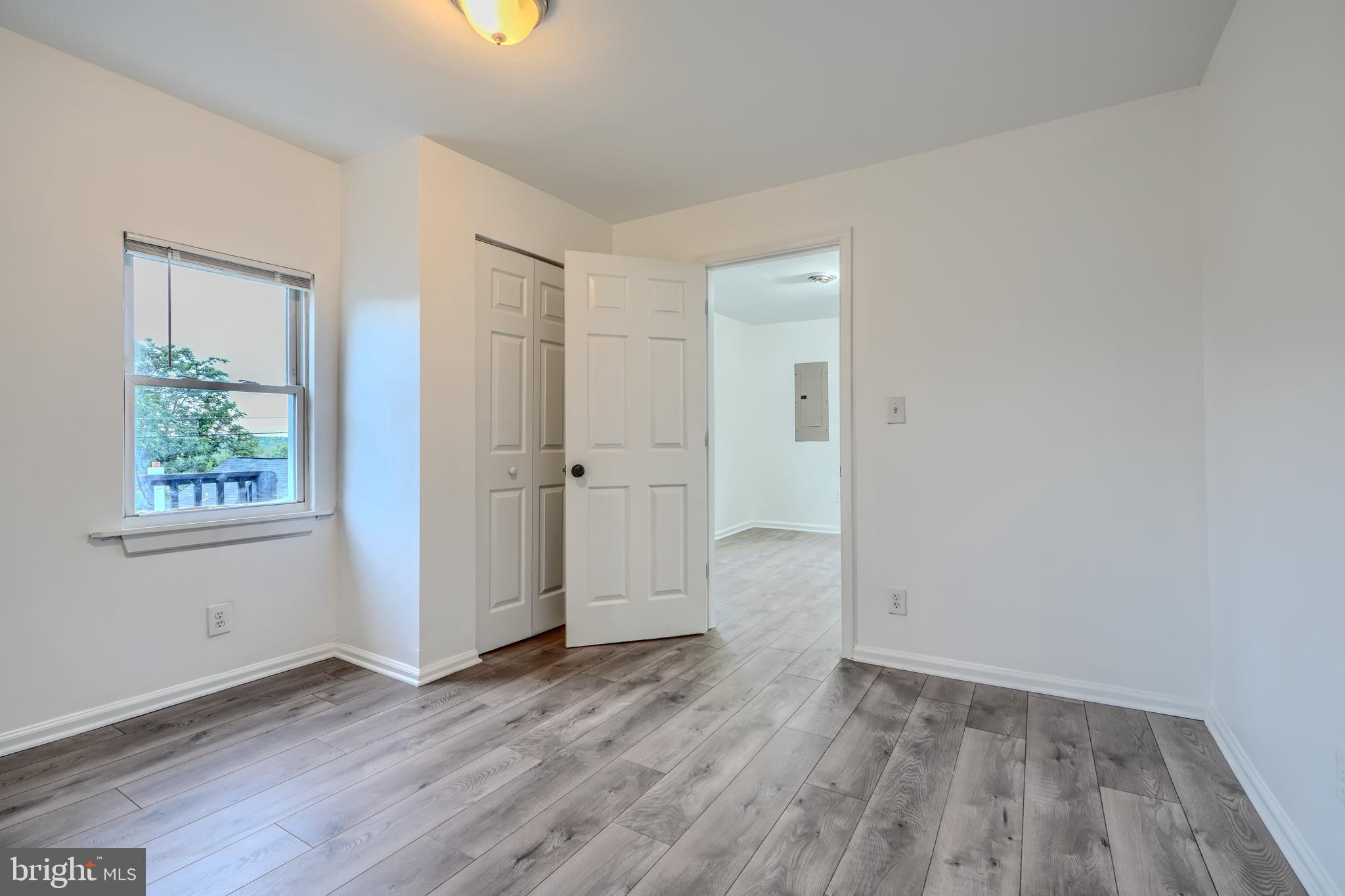 227 Elizabeth Avenue Baltimore, MD 21225 - Photo 21 of 31 an empty room with wooden floor and windows