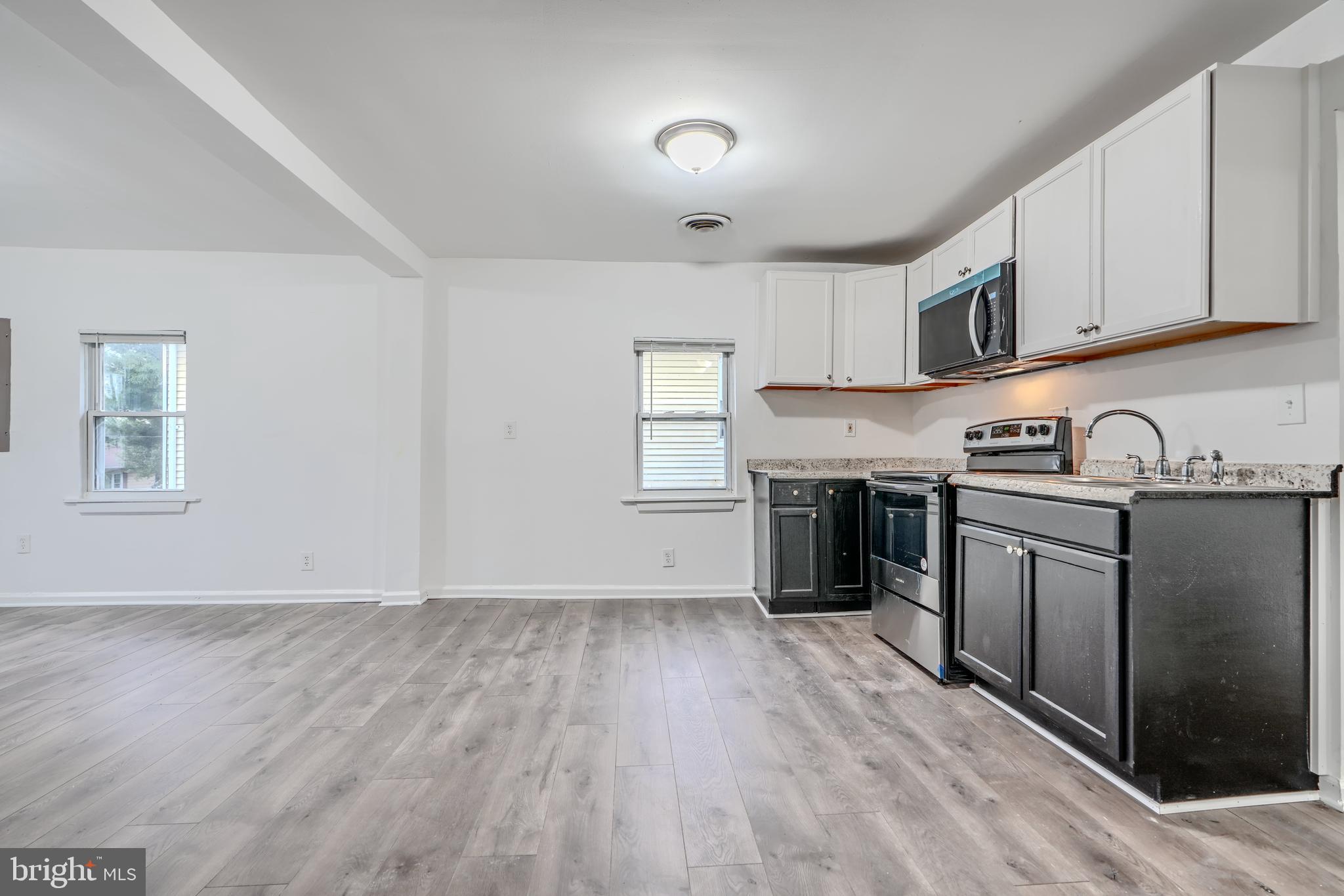 227 Elizabeth Avenue Baltimore, MD 21225 - Photo 7 of 31 a kitchen with granite countertop a stove top oven and cabinets