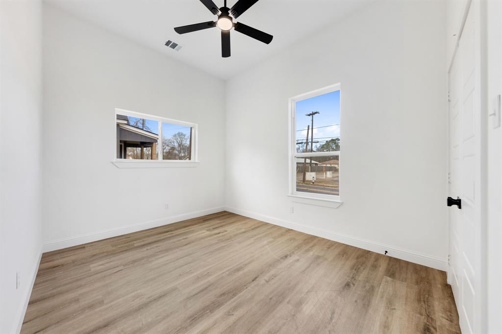 1269 Bonham Street Paris, TX 75460 - Photo 11 of 19 a view of an empty room with a window and a ceiling fan
