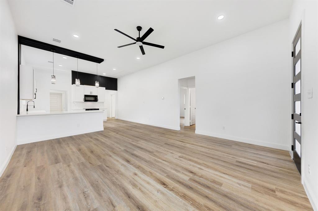1269 Bonham Street Paris, TX 75460 - Photo 2 of 19 a view of empty room with wooden floor and ceiling fan