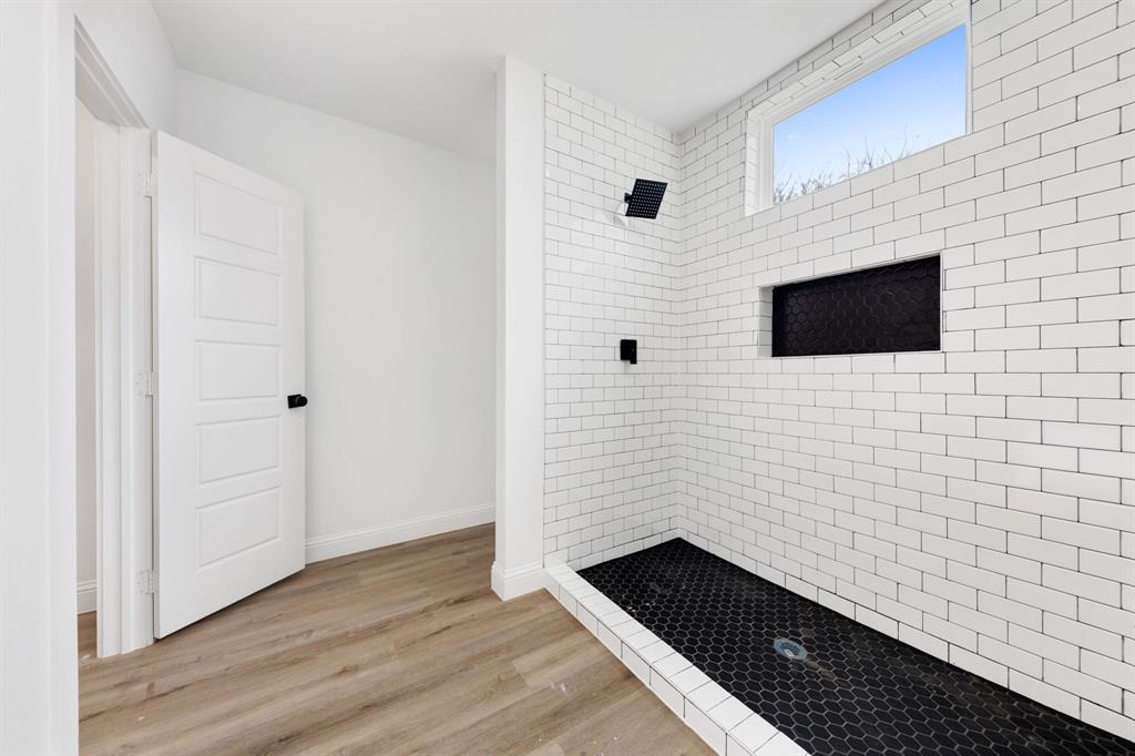 1269 Bonham Street Paris, TX 75460 - Photo 8 of 19 a bathroom with a shower and a flat screen tv