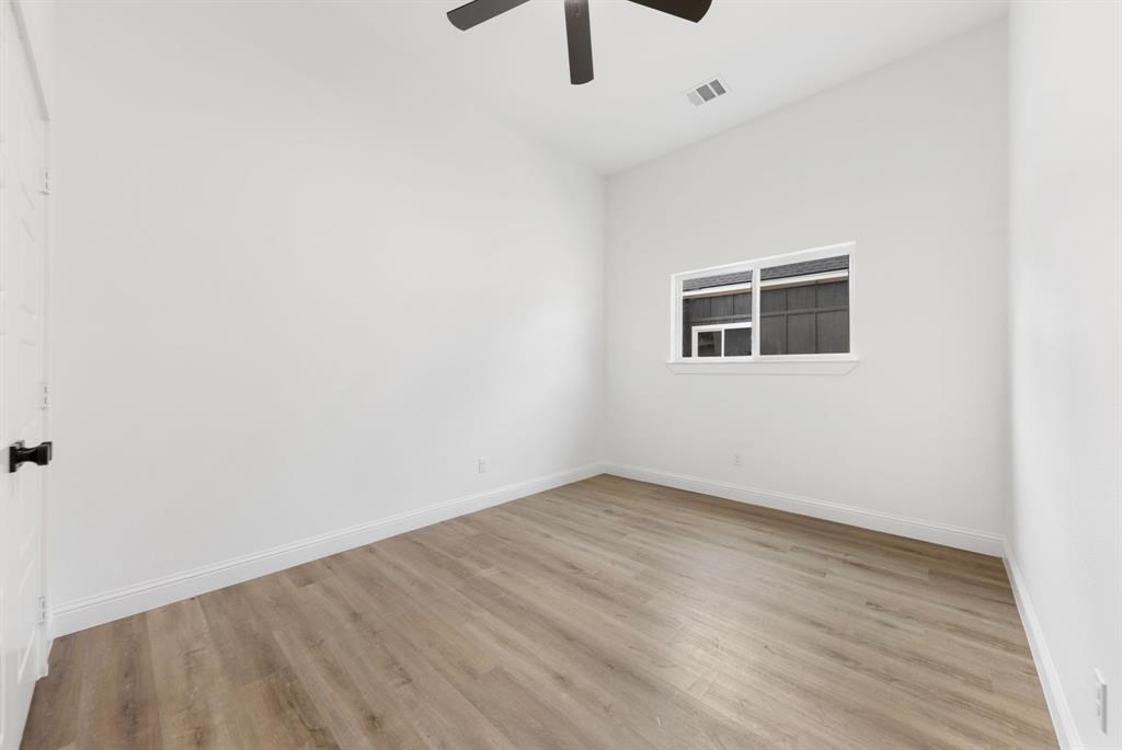1269 Bonham Street Paris, TX 75460 - Photo 10 of 19 an empty room with wooden floor and windows