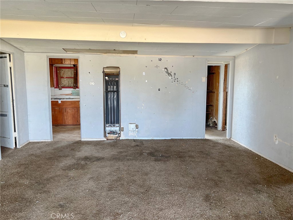 27154 Anderson Street Boron, CA 93516 - Photo 3 of 12 a view of a hallway with a wooden door