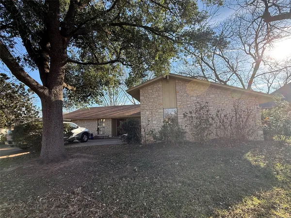 a view of backyard of house with car parked