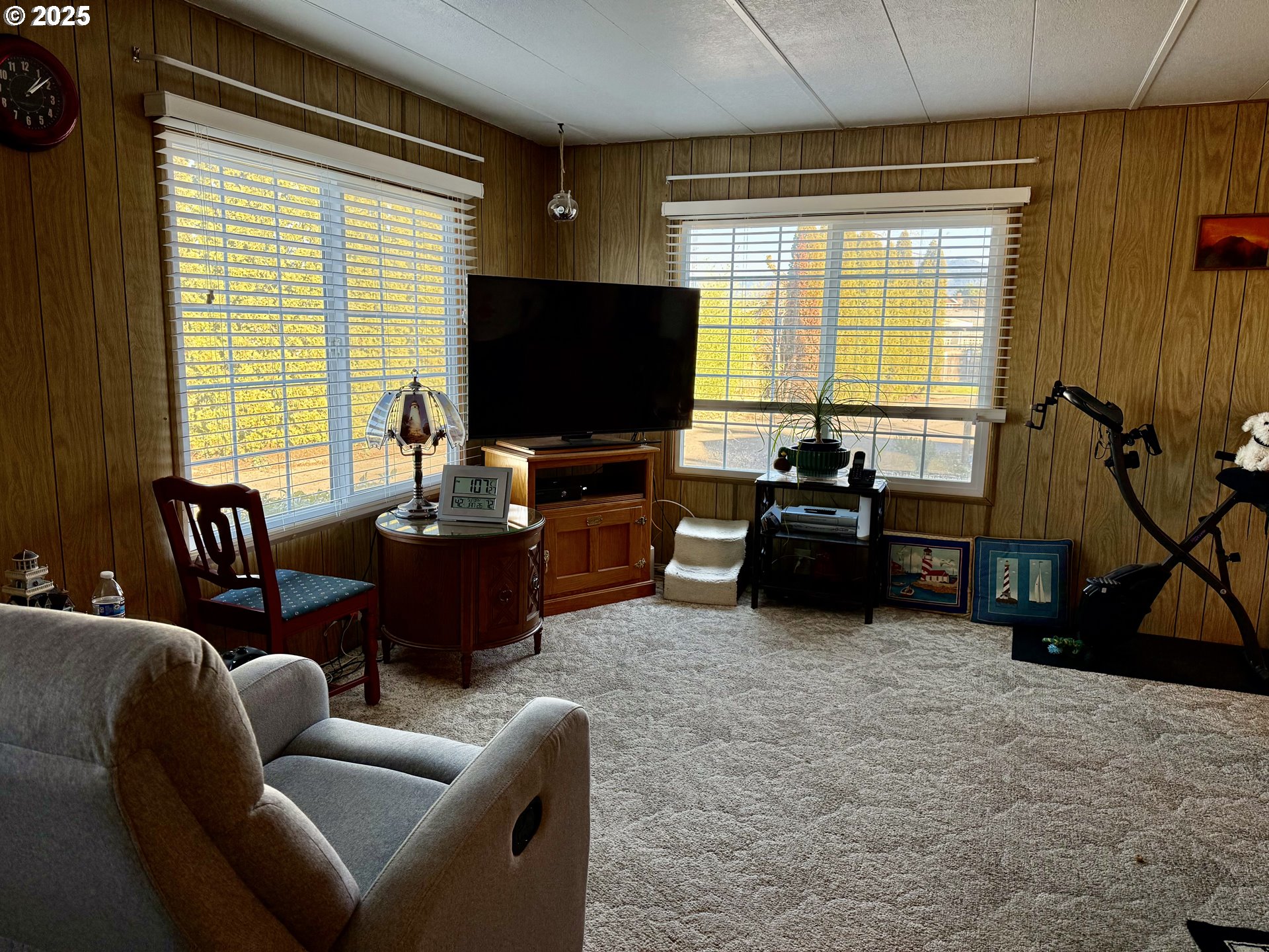 1475 Green Acres Road, Unit 40 Eugene, OR 97408 - Photo 7 of 30 a living room with furniture a flat screen tv and a large window