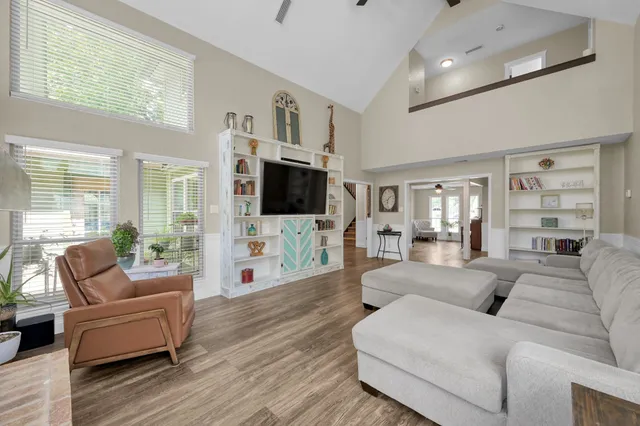 a living room with furniture a flat screen tv and wooden floor
