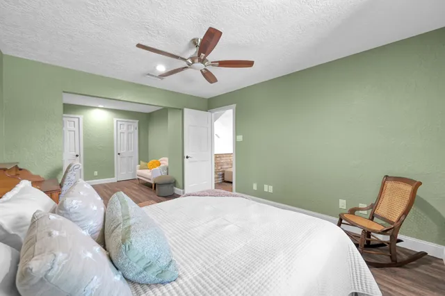 a bedroom with a bed a chair and window