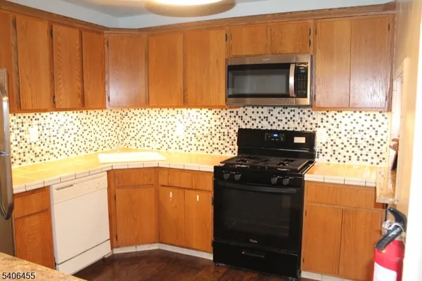 a kitchen with granite countertop cabinets and black appliances