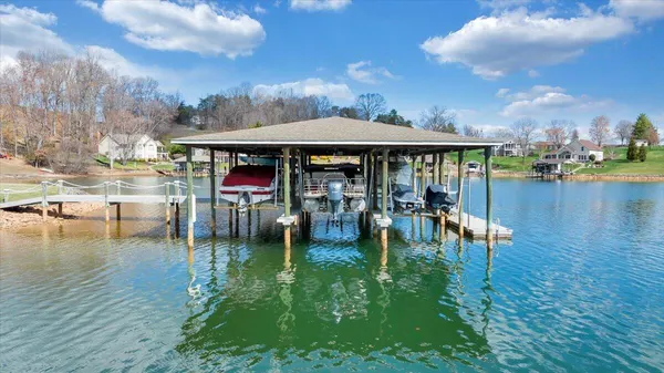 a kitchen with stainless steel appliances granite countertop a stove top oven a sink dishwasher a dining table and chairs with wooden floor