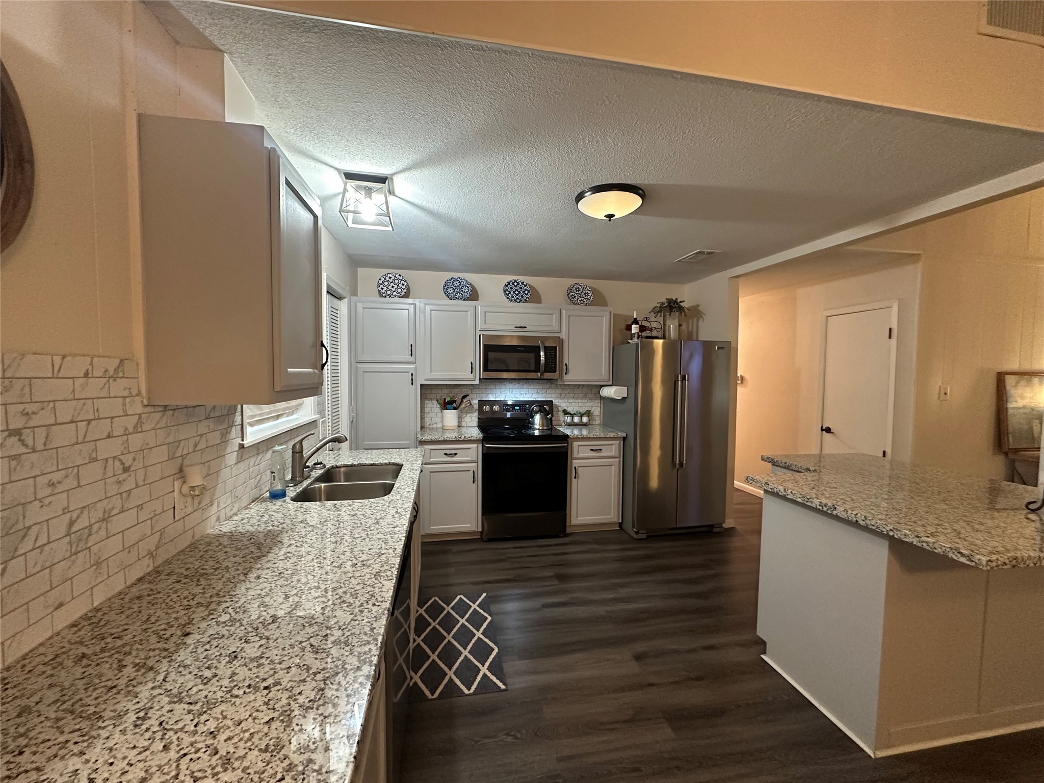510 Ray Street Buffalo, TX 75831 - Photo 16 of 43 a large kitchen with granite countertop a stove a sink and a refrigerator