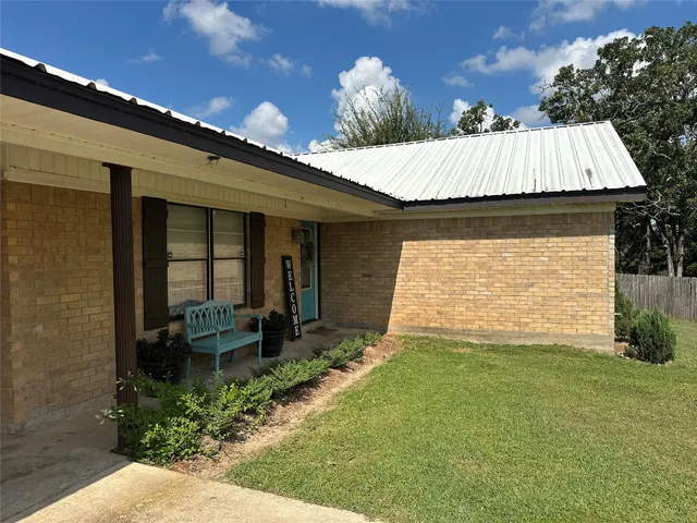 a view of a house with backyard and sitting area