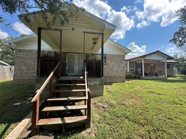 a backyard of a house with table and chairs