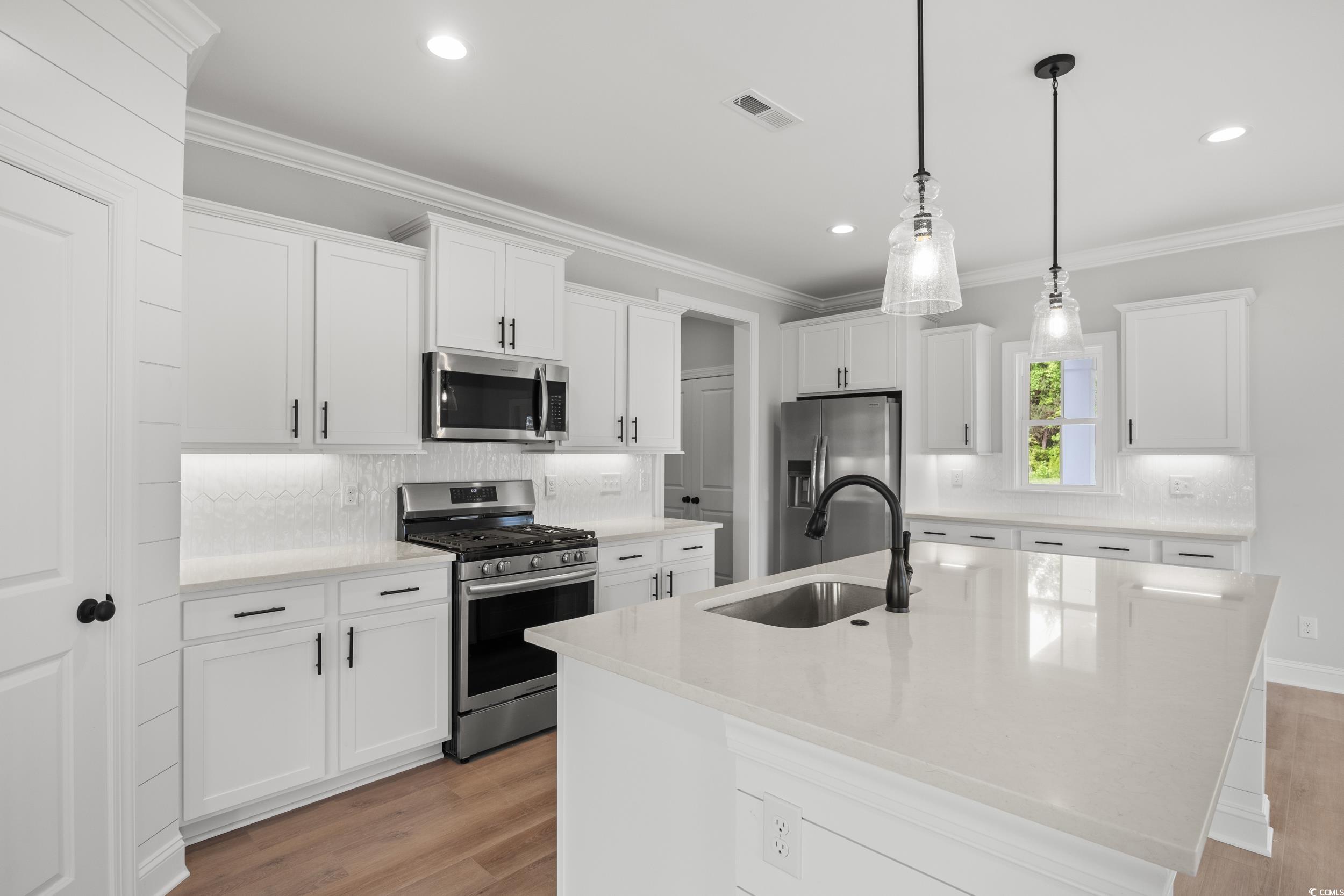 1201 Possum Trot Road North Myrtle Beach, SC 29582 - Photo 4 of 33 Kitchen with stainless steel appliances, a sink, light wood-style floors, backsplash, and recessed lighting