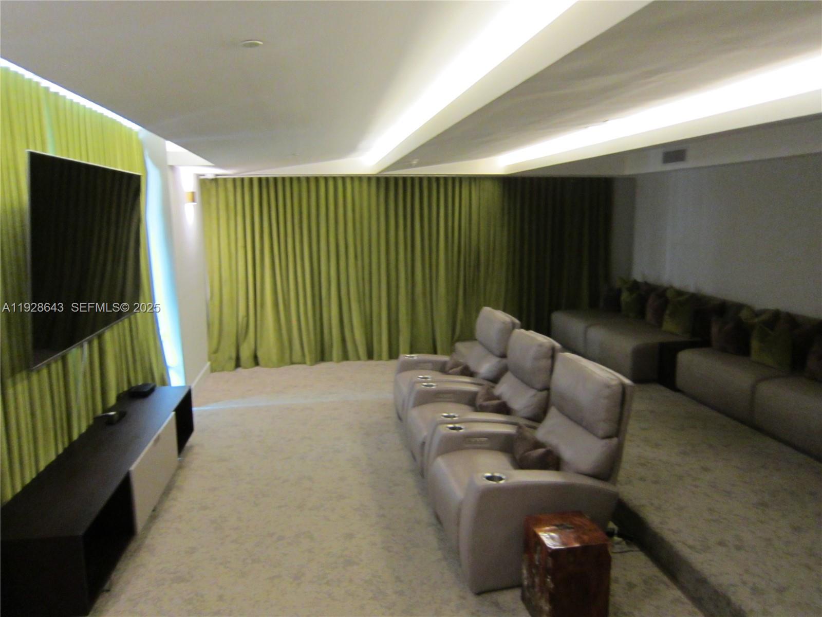 488 Northeast 18th Street, Unit 1804 Miami, FL 33132 - Photo 34 of 42 a living room with furniture a flat screen tv and a large window