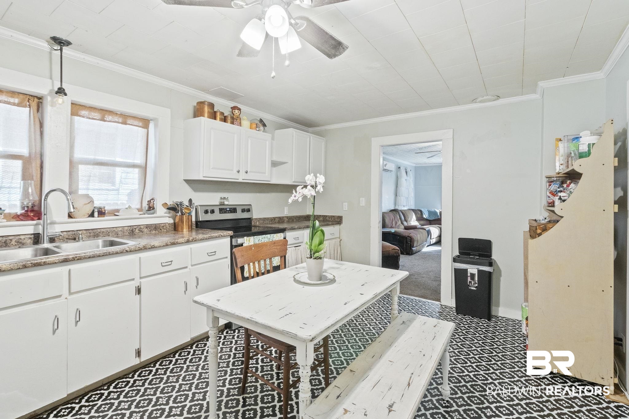 707 North Cedar Street Foley, AL 36535 - Photo 17 of 69 Kitchen with sink, white cabinets, light carpet, stainless steel electric stove, and crown molding