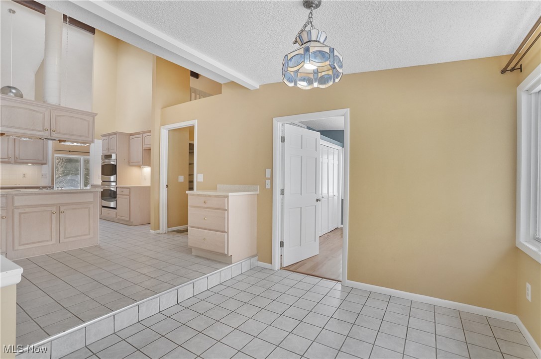 1094 San Raphael Drive Akron, OH 44333 - Photo 18 of 50 Kitchen with light tile patterned floors, hanging light fixtures, a textured ceiling, light countertops, and light brown cabinets