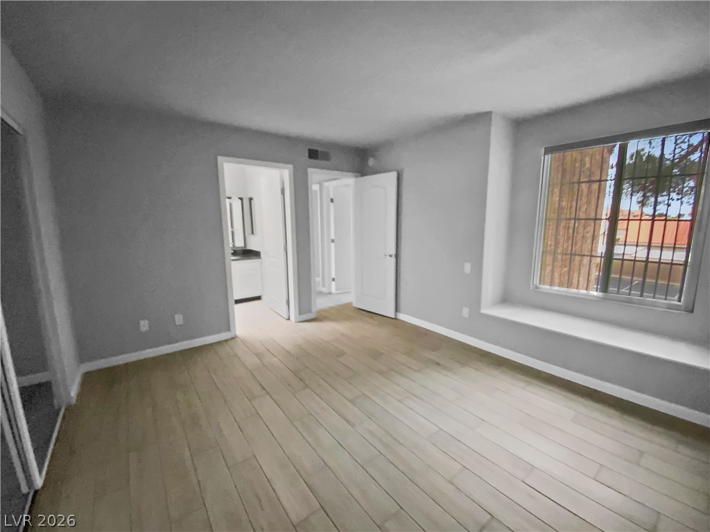 9325 West Desert Inn Road, Unit 278 Las Vegas, NV 89117 - Photo 6 of 17 Hardwood floors and a deep window seat define this adaptable bedroom space.