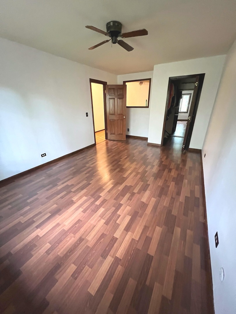 7749 West Harbor Court Frankfort, IL 60423 - Photo 16 of 17 a view of empty room with wooden floor and fan