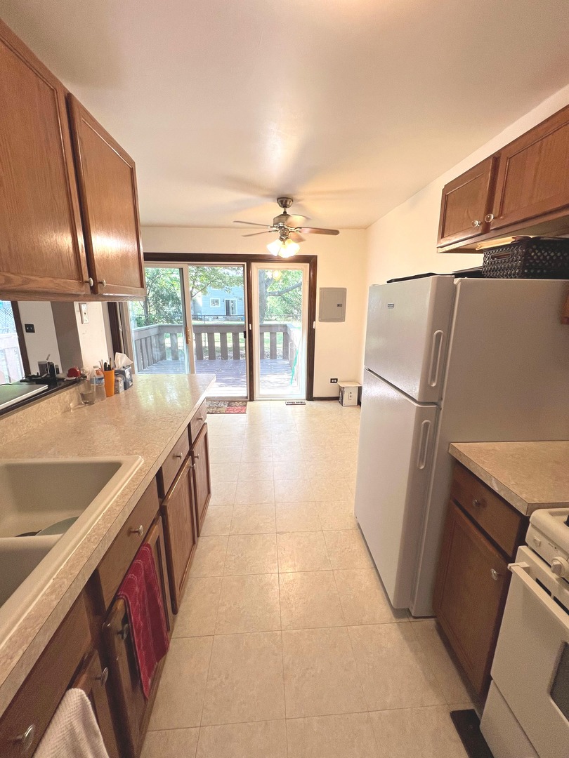 7749 West Harbor Court Frankfort, IL 60423 - Photo 9 of 17 a kitchen with a refrigerator a stove and a sink with wooden floor