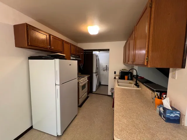 a kitchen with refrigerator a microwave a sink and cabinets