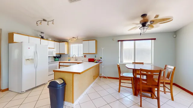 a kitchen with stainless steel appliances a dining table chairs and granite counter tops