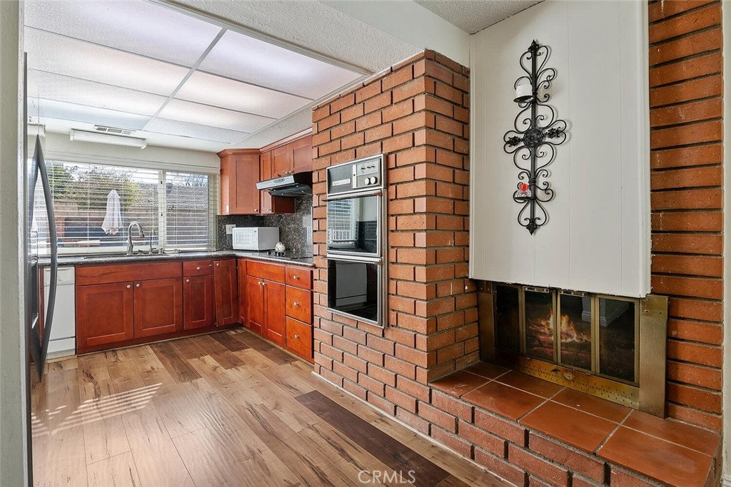 23850 Vía Jacara Valencia, CA 91355 - Photo 14 of 41 a kitchen with stainless steel appliances kitchen island granite countertop a stove a sink and a microwave