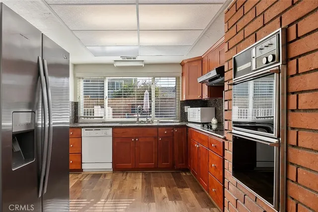 a kitchen with stainless steel appliances granite countertop a sink and cabinets
