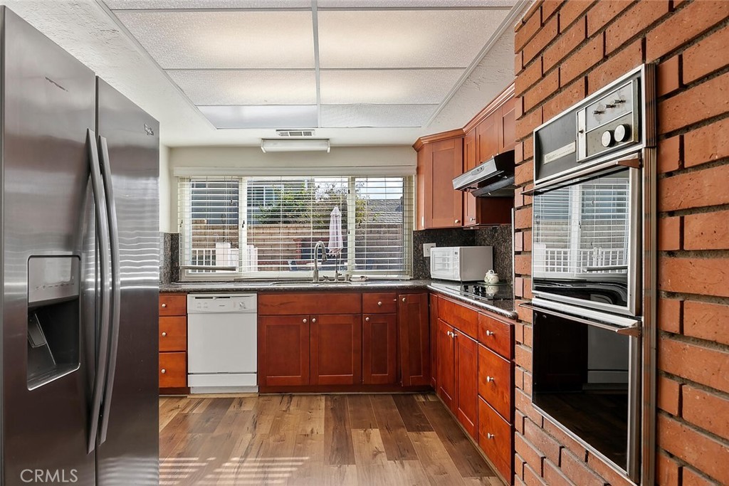 23850 Vía Jacara Valencia, CA 91355 - Photo 15 of 41 a kitchen with stainless steel appliances granite countertop a sink and cabinets