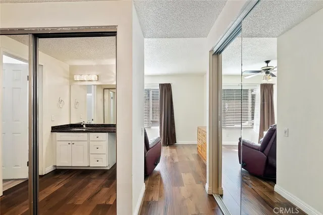 a kitchen with granite countertop a refrigerator and a wooden floor