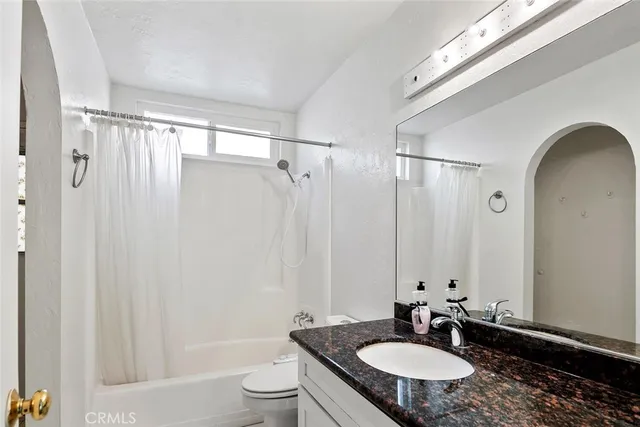 a bathroom with a sink toilet a mirror and shower