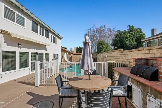 a view of a patio with table and chairs with wooden floor and fence