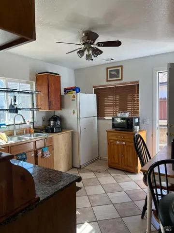 a kitchen with a refrigerator and a stove top oven