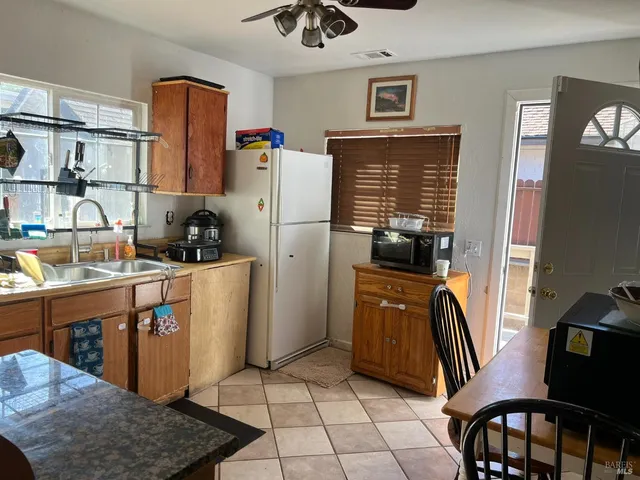 a kitchen with stainless steel appliances granite countertop a refrigerator and a stove top oven