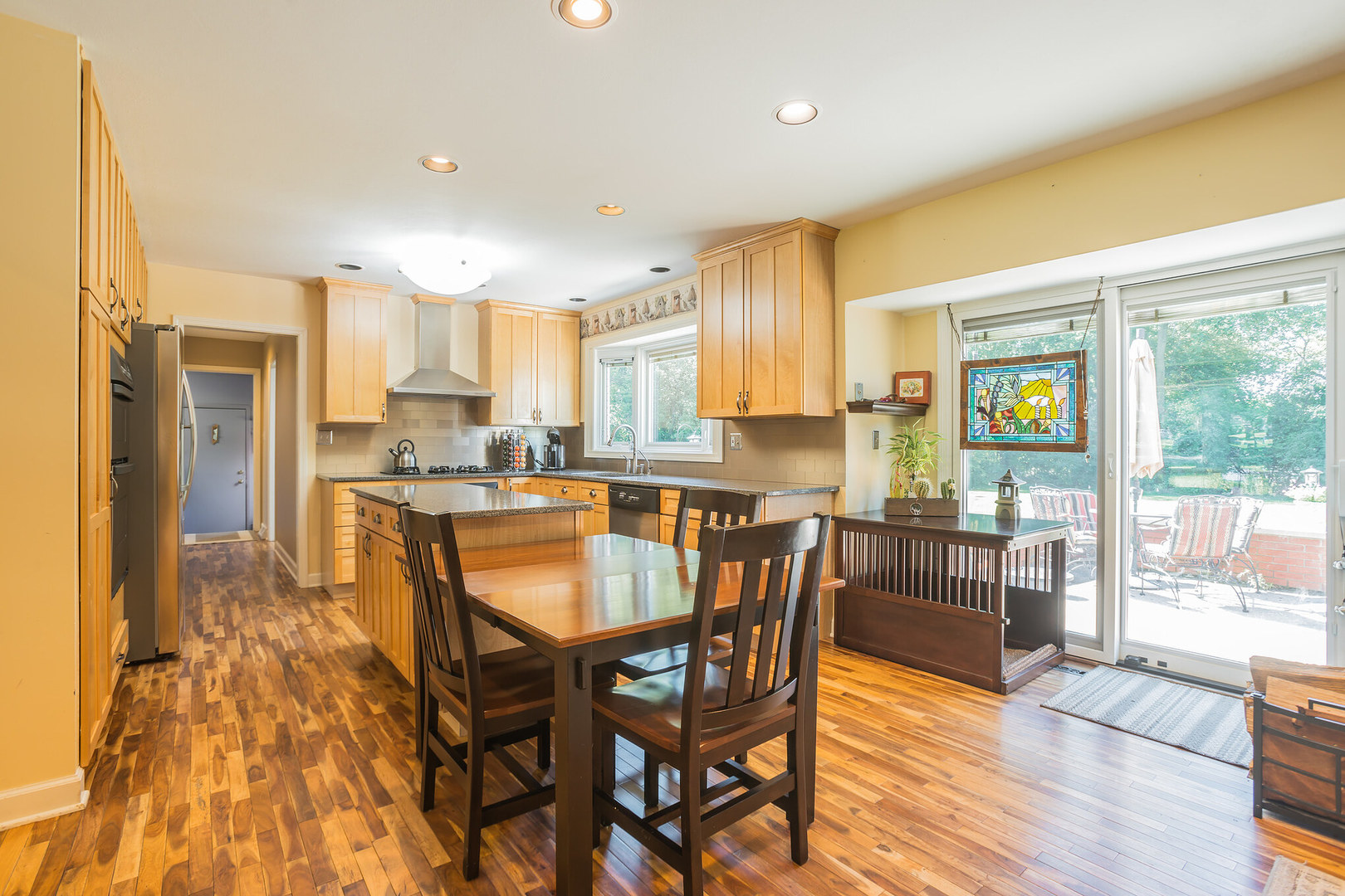234 Valley Road Trout Valley, IL 60013 - Photo 8 of 29 a kitchen with stainless steel appliances granite countertop wooden floor cabinets and a table