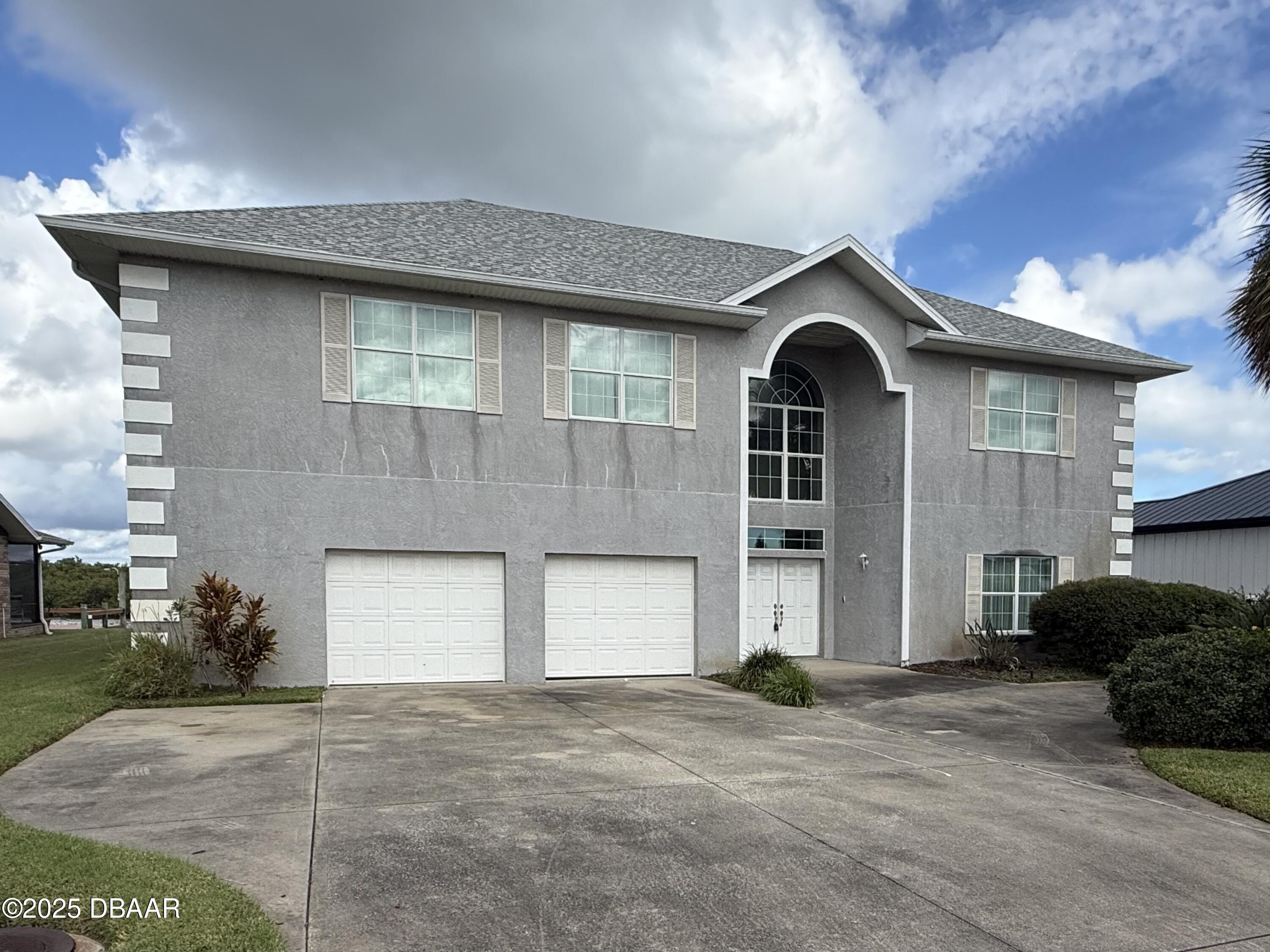 126 Carriage Ponce Inlet, FL 32127 - Photo 14 of 20 a front view of a house with a yard and garage