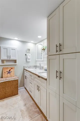 a spacious bathroom with a double vanity sink a mirror and a bathtub