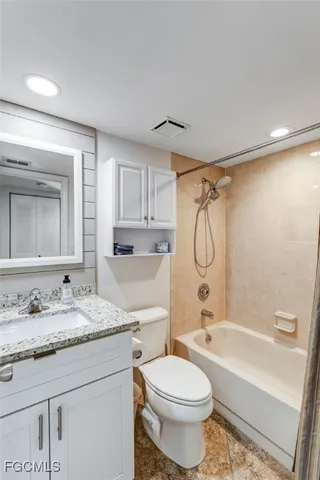a bathroom with a granite countertop sink mirror toilet and bathtub
