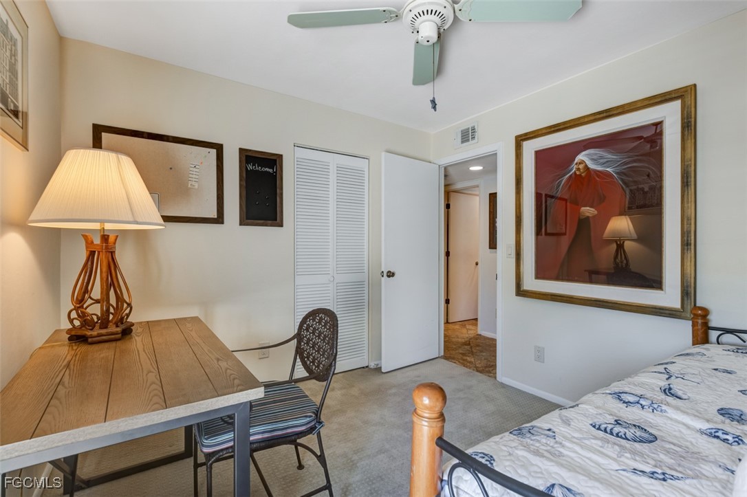5710 Trailwinds Drive, Unit 525 Fort Myers, FL 33907 - Photo 25 of 37 a bedroom with a bed and a lamp on table