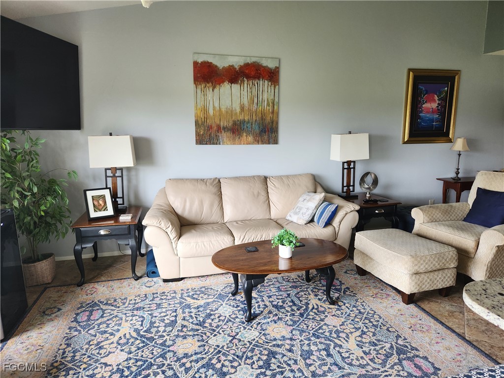 5710 Trailwinds Drive, Unit 525 Fort Myers, FL 33907 - Photo 6 of 37 a living room with furniture and a rug