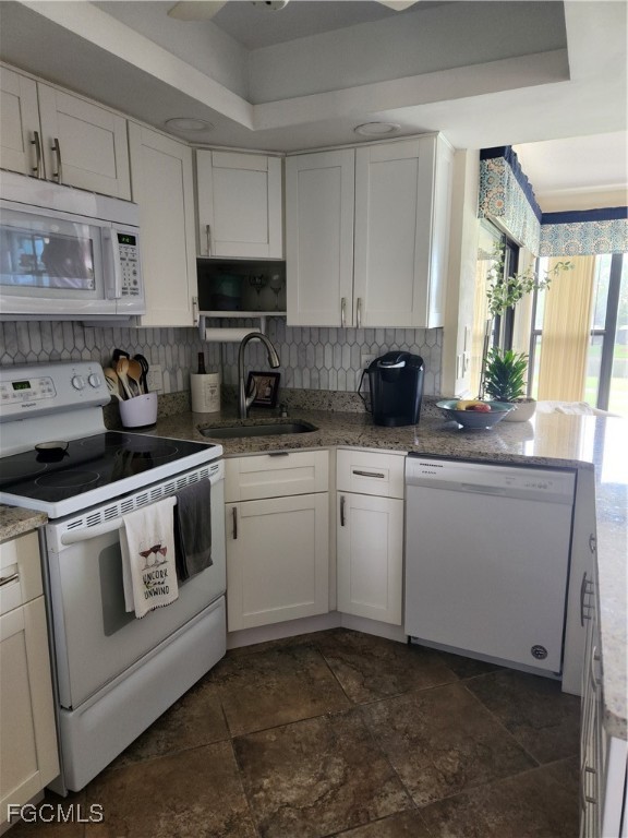5710 Trailwinds Drive, Unit 525 Fort Myers, FL 33907 - Photo 9 of 37 a kitchen with white cabinets and white appliances