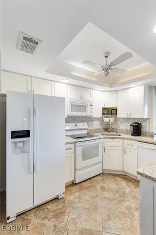 a kitchen with granite countertop cabinets and refrigerator