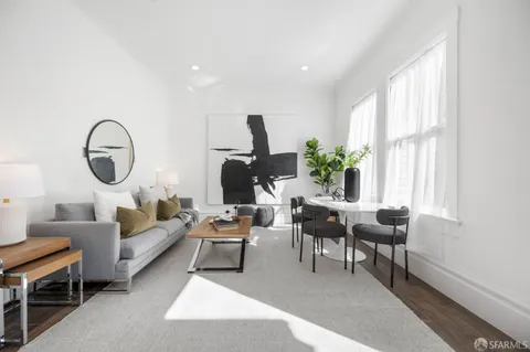 a living room with furniture a rug a window and a potted plant
