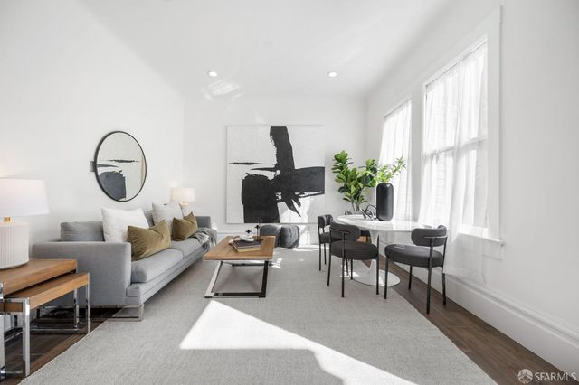 a living room with furniture a rug a window and a potted plant
