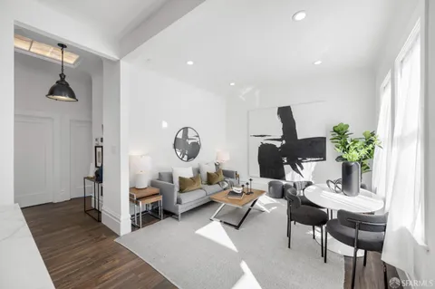 a living room with furniture a rug and a potted plant