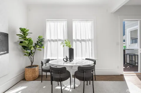 a kitchen with kitchen island granite countertop wooden floors white cabinets and stainless steel appliances