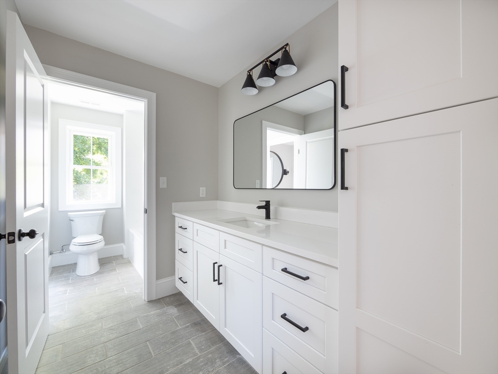 5 Stanley Street Natick, MA 01760 - Photo 14 of 21 a bathroom with a double vanity sink mirror and toilet