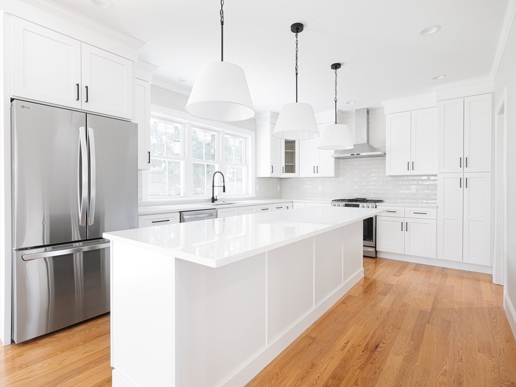 5 Stanley Street Natick, MA 01760 - Photo 6 of 21 a kitchen with stainless steel appliances granite countertop a sink a stove a refrigerator and island with wooden floor