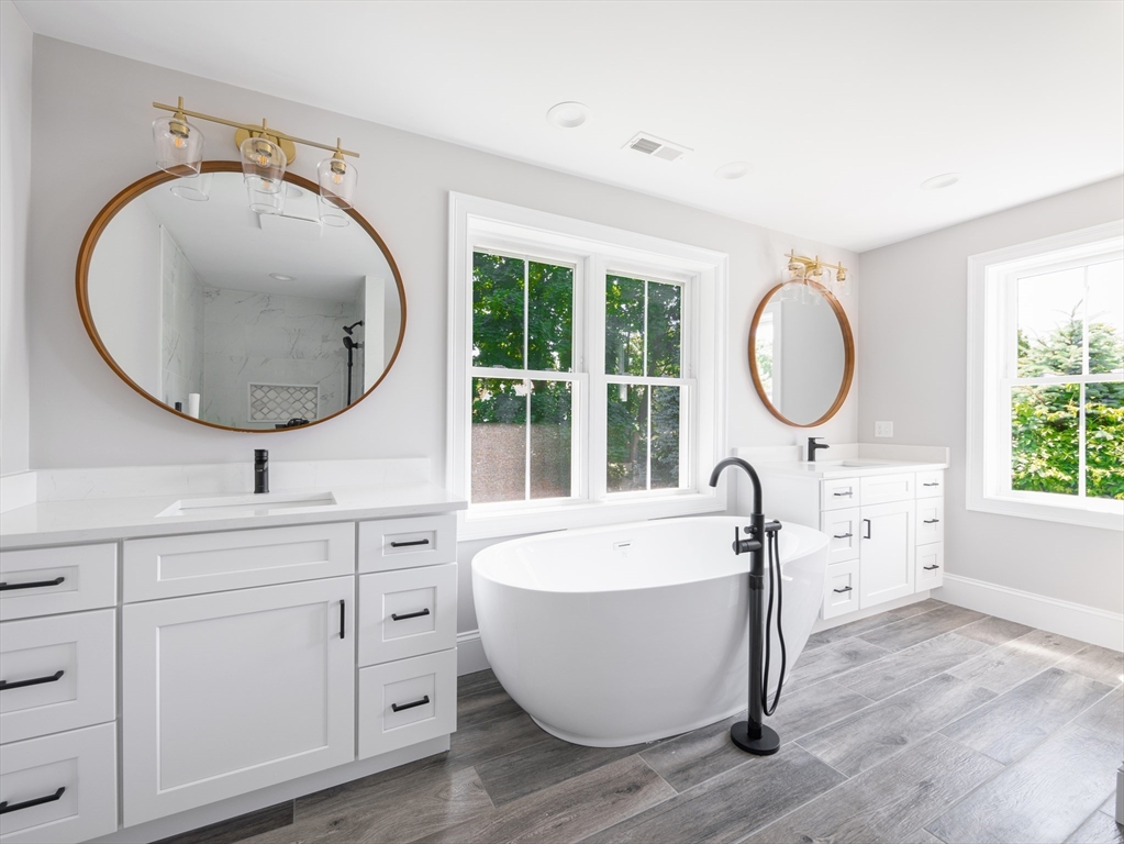5 Stanley Street Natick, MA 01760 - Photo 10 of 21 a bathroom with a bathtub a sink and a mirror